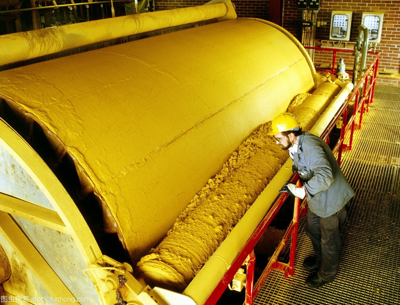 模型发布。涂料制造。技术人员观察用于制造黄色颜料的机器。颜料的颜色来自于它里面的氧化铁。
